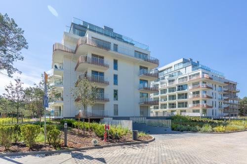 a white apartment building with a street in front of it at Apartpark - Ambria Apartments in Świnoujście