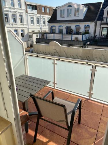 a balcony with a bench and a chair on a roof at Hotel Restaurant Ennen in Norderney