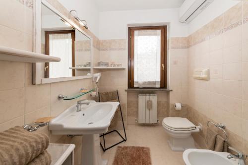 a bathroom with a sink and a toilet and a mirror at Villa Alida Casa Vacanze in Foligno