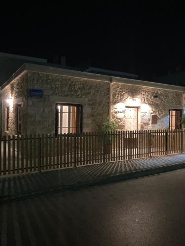 a stone building with a fence and lights on it at Reina House in Chania
