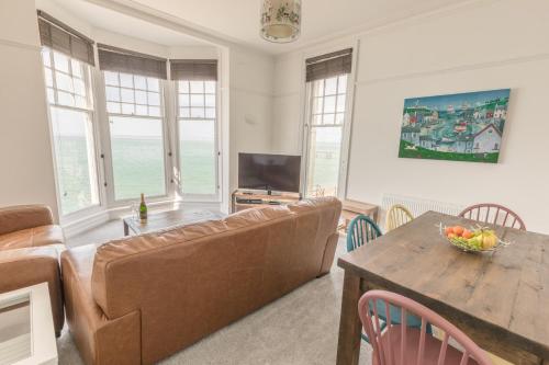 a living room with a couch and a table at Pier View Apartment in Totland