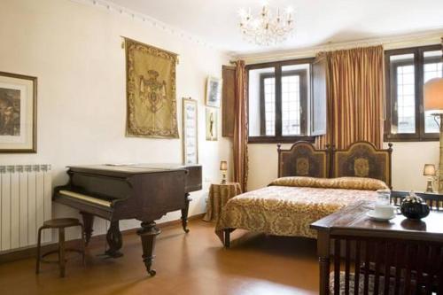 1 dormitorio con piano, cama y mesa en Lungarno Ponte Vecchio, en Florencia
