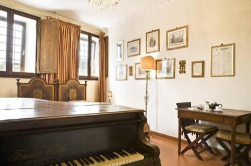 Habitación con piano, escritorio y lámpara. en Lungarno Ponte Vecchio, en Florencia