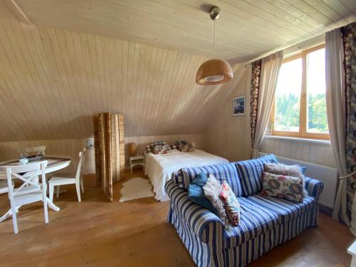- une chambre avec un canapé et un lit dans l'établissement Apartament Babia Góra, à Zawoja
