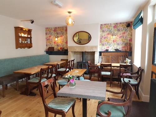 a restaurant with wooden tables and chairs and a fireplace at The Railway in Skipton