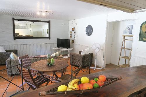 a living room with a table with a bowl of fruit at Ranch Black Horse in Les Trois-Îlets