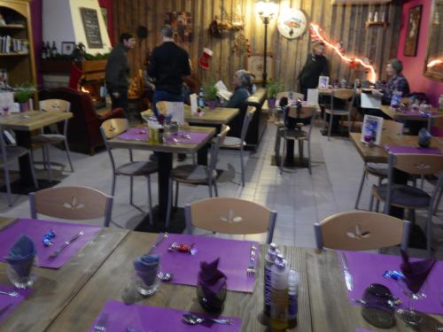 a restaurant with purple tables and chairs and people at Hostellerie de Rimplas in Rimplas