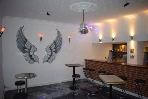 eine Bar mit zwei Flügeln an einer Wand mit Hockern in der Unterkunft Hotel Ratsstuben Kalbe in Kalbe