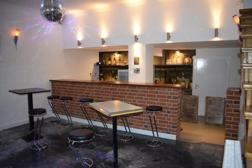 a bar with stools in front of a brick wall at Hotel Ratsstuben Kalbe in Kalbe