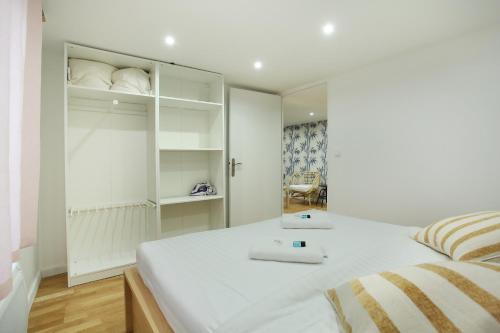 a bedroom with a white bed with a mirror at Rent a Room - Cosy 2BDR in Paris