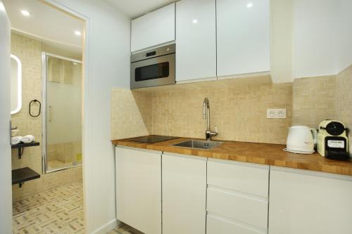 a kitchen with white cabinets and a sink at Rent a Room - Cosy 2BDR in Paris