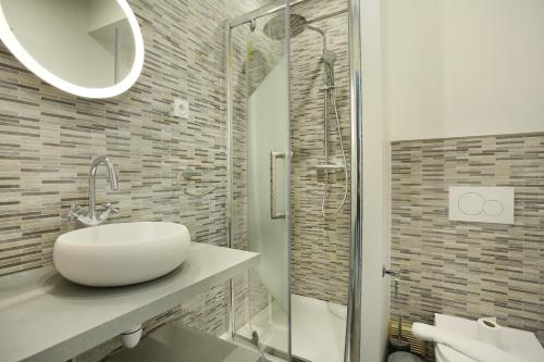 une salle de bain blanche avec un lavabo et une douche dans l'établissement Rent a Room - Cosy 1BDR, à Paris