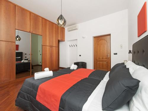 a bedroom with a large bed with an orange and black blanket at Retro Rooms Termini in Rome