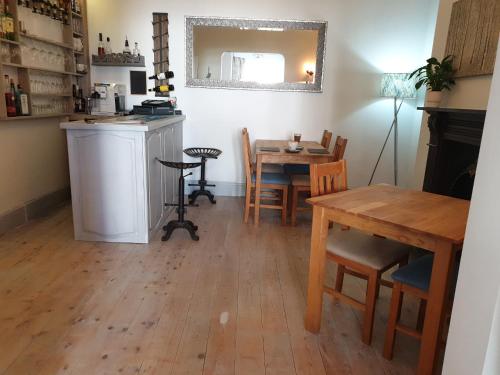 cocina y comedor con mesa y sillas en Glascoed Guest House, en Llandudno