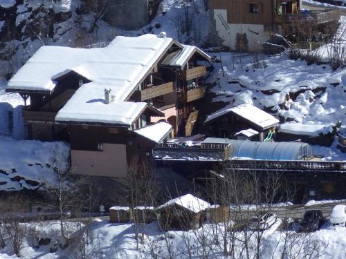 ein schneebedecktes Haus mit einem Zug in der Unterkunft Résidence Les Edelweiss in Champagny-en-Vanoise