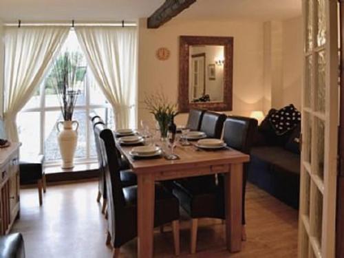 a dining room with a table with chairs and a couch at The Granary in Carperby