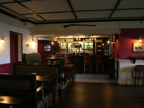 a restaurant with a bar with tables and chairs at The Rifle Volunteer in Ware