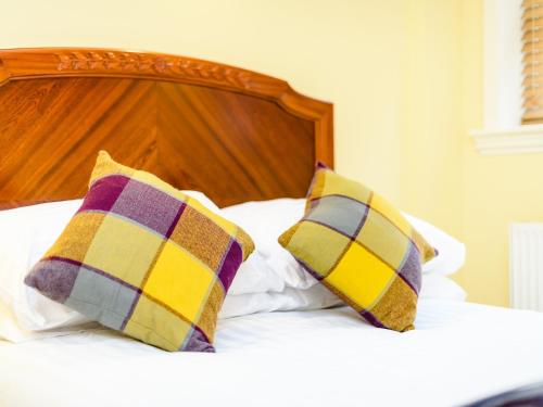 a bed with two pillows on top of it at 1 Riverside Apartments in Norwich