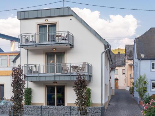 a white house with balconies on a street at Rochter Apartments in Zeltingen-Rachtig