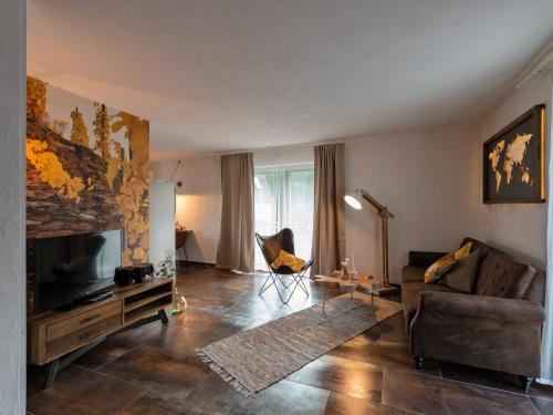 a living room with a couch and a television at Rochter Apartments in Zeltingen-Rachtig