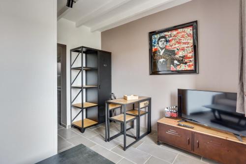 a living room with a tv and a entertainment center at Roissy Appartements in Roissy-en-France