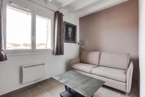 sala de estar con sofá y mesa en Roissy Appartements en Roissy-en-France