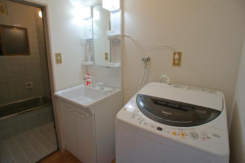 a bathroom with a washing machine and a sink at Gion Rokudo in Kyoto