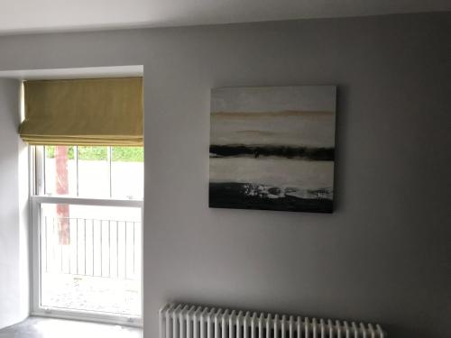 a painting hanging on a wall next to a window at No.16 in Seaham