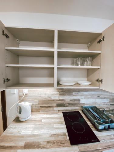 a kitchen with white cabinets and a counter top at Chaty a Apartmány Hracholusky Kemp Kosatka in Pňovany