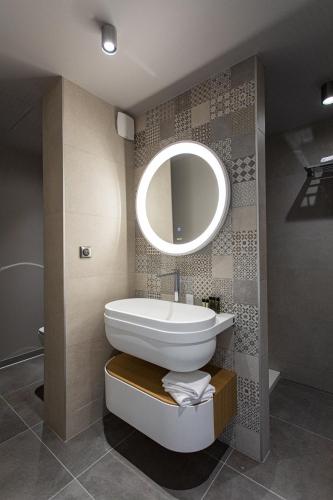 a bathroom with a sink and a mirror at Hôtel L'Ouvrée in Savigny-lès-Beaune