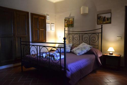 Un dormitorio con una cama con sábanas moradas y una lámpara. en Agriturismo Selvapiana en Cantagallo