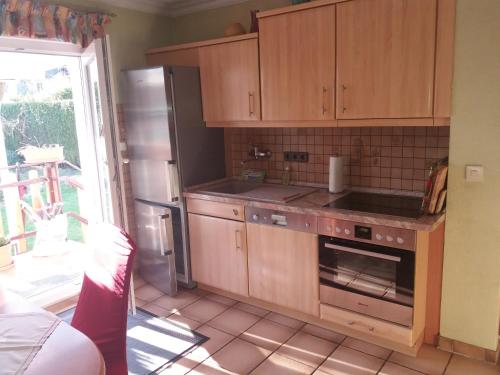 a kitchen with wooden cabinets and a stove top oven at Ferienwohnung Konz in Merzig