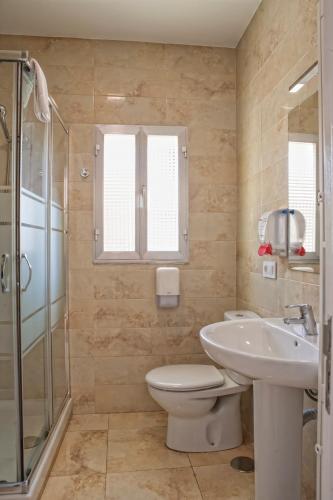 a bathroom with a toilet and a sink and a shower at LAS CASITAS DEL VERDEL in Suances