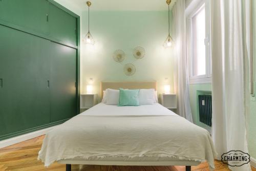 a bedroom with a large bed with a green wall at Charming Gran Vía Center in Madrid