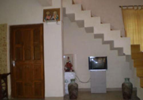 a room with a staircase and a tv and a door at Drisl Villa 3BHK in Alibaug