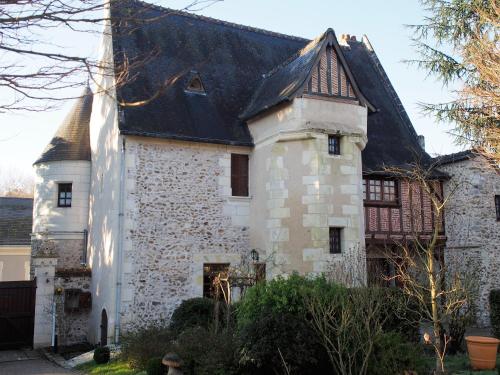 uma antiga casa de pedra com um telhado preto em Manoir du Rouvre em Mettray