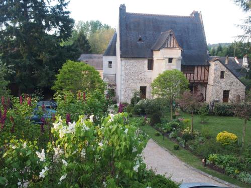 uma casa antiga com um jardim em frente em Manoir du Rouvre em Mettray