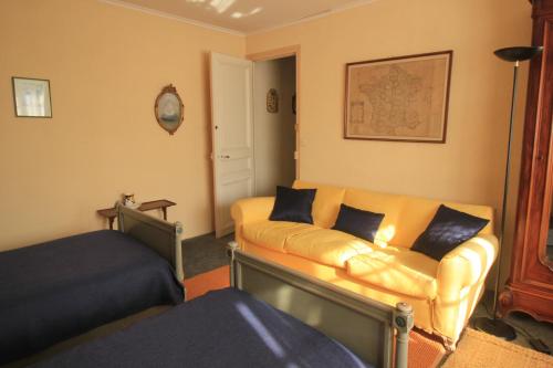 a living room with a couch and a bed at L Ancienne Ferme 17 grand rue in Connantre