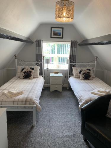 a bedroom with two beds and a window at Launceston Villa in Whitby