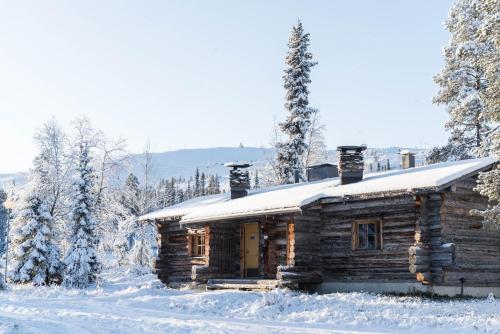 a log cabin in the snow with trees at Lapland Hotels Luostotunturi & Amethyst Spa in Luosto