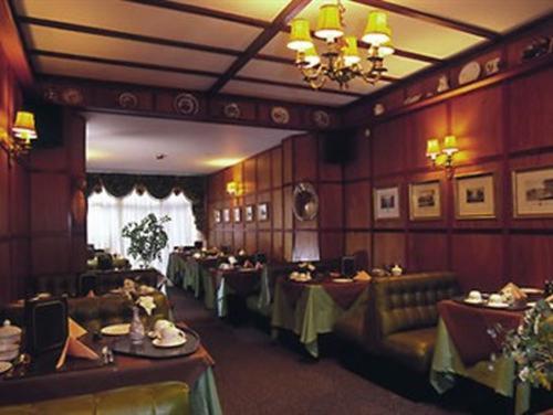 法爾茅斯的住宿－Rosemullion Hotel，一间带桌椅和吊灯的用餐室