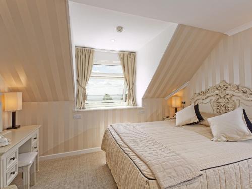 a bedroom with a large bed and a window at Rosemullion Hotel in Falmouth