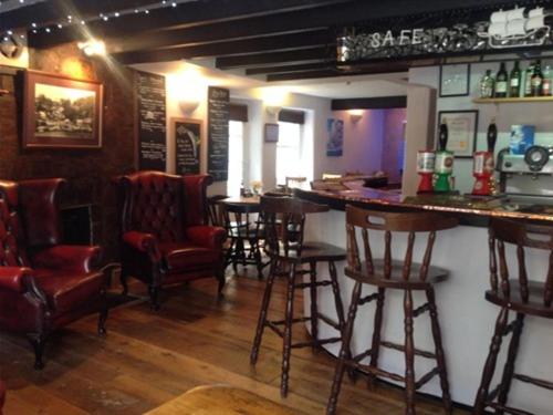 un bar con sillas y un mostrador en un pub en The Safe Harbour Hotel, en Fowey