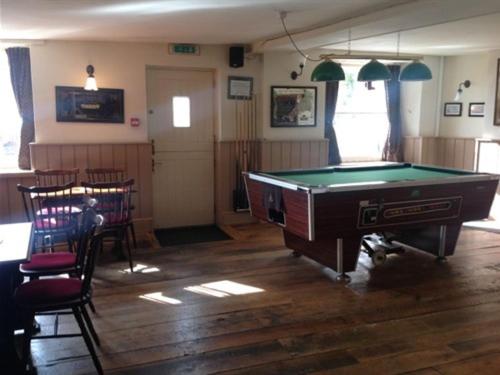 a room with a pool table and some chairs at The Safe Harbour Hotel in Fowey