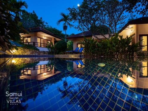 a villa with a swimming pool at night at Samui Secret Villas in Choeng Mon Beach
