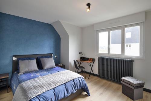 1 dormitorio con 1 cama grande y pared azul en Le MoZen - Appartement proche hippodrome - St Malo, en Saint-Malo