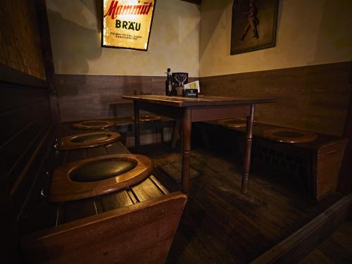 a room with a table and four wooden toilets at Pension Rüssel-Pub in Sangerhausen