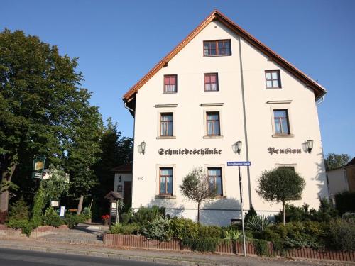 een wit gebouw met de naam van het hotel bij Pension Schmiedeschänke in Dresden