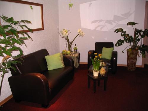 a living room with a leather couch and two chairs at Hotel Schöne Aussicht in Steinach