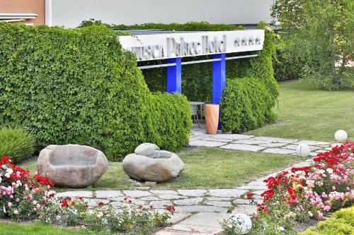 a building with two stone benches in a garden at Anusca Palace Hotel in Castel San Pietro Terme